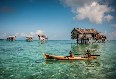 Panoramic view of people in sea against sky