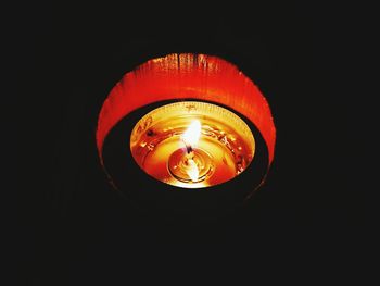 Close-up of lit light bulb at night