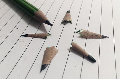 Close-up of pencil by shavings on paper
