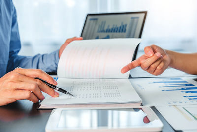 Cropped image of man using laptop on table