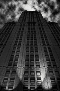Low angle view of modern building against cloudy sky