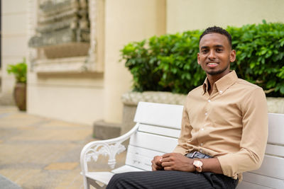 Portrait of smiling young man sitting outdoors