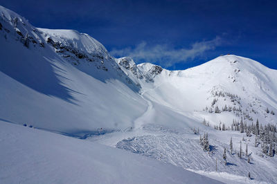 Scenic view of snow covered mountains against sky