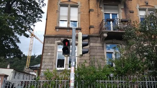 Low angle view of road sign against trees in city