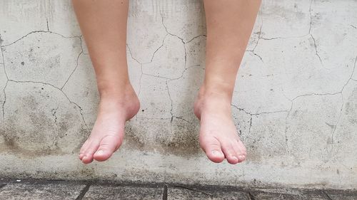 Low section of woman standing on footpath