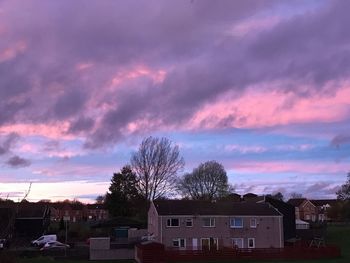 Houses against sky at sunset