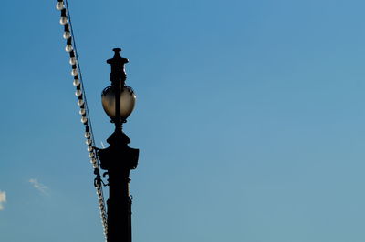 Low angle view of street light against clear blue sky