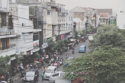 Traffic on road amidst buildings in city