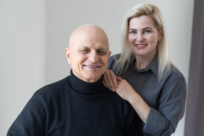 Old father with young girl standing isolated over white background