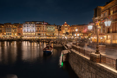 Canal passing through city buildings at night