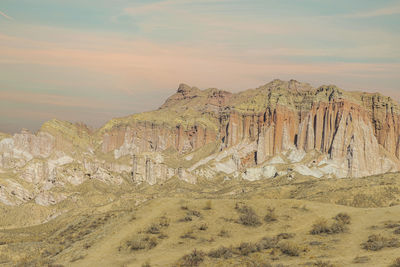 Rock formations on landscape against sky during sunset