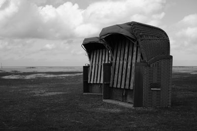 Abandoned hut on grass at beach