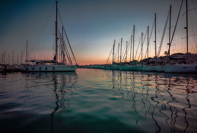 Sailboats in marina at sunset