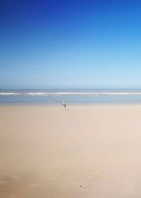 Scenic view of beach against clear blue sky