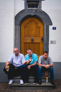 People sitting at entrance of building