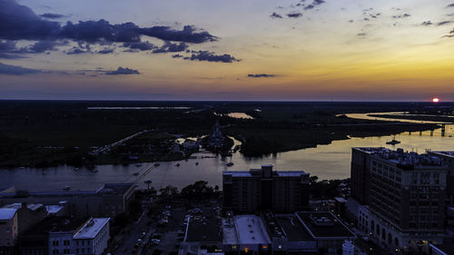 High angle view of buildings and sea against sky during sunset