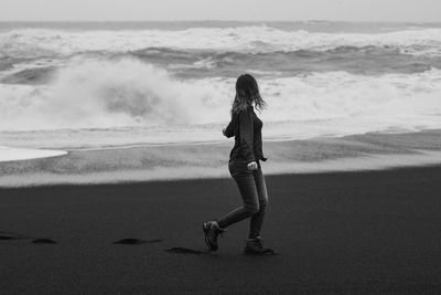 Woman looking at stormy sea on beach monochrome scenic photography