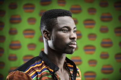 Close-up of young man against green wall