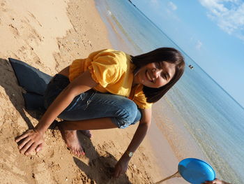 Smiling young woman on sand at beach