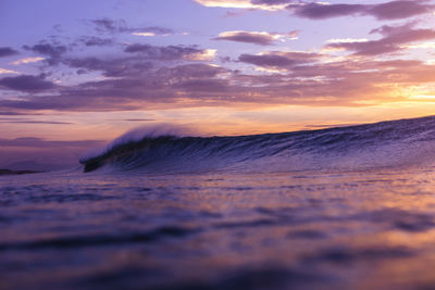 Wave breaking close to the shores of france with sunset colors.