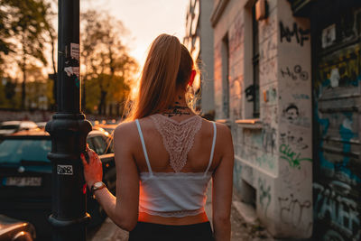 Rear view of woman standing on text in city