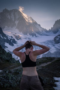 Young woman standing on mountain against sky