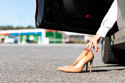 Woman changes clothes in comfortable shoes before driving, sitting in car, close up