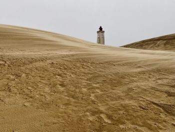 Lighthouse on desert against clear sky