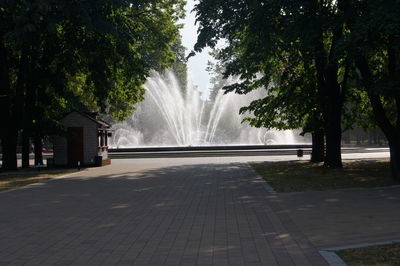 Fountain in park by street in city