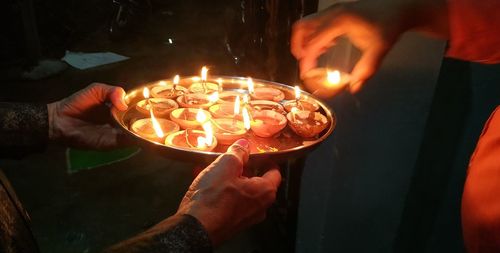 High angle view of hand holding lit candles