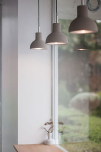 Close-up of illuminated pendant light hanging against wall