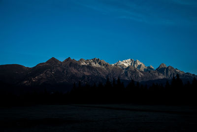 Scenic view of mountains against blue sky