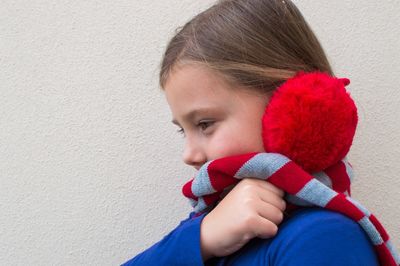 Close-up portrait of girl holding red leaf