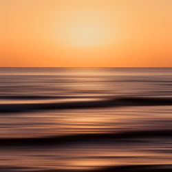 Scenic view of sea against orange sky