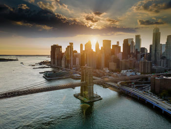 Scenic view of sea and buildings against sky during sunset