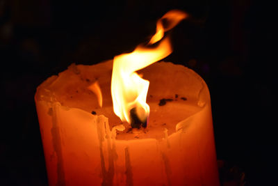 Close-up of burning candle in dark room