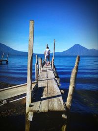 Rear view of man looking at sea against sky