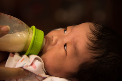 Cropped hand of person feeding baby