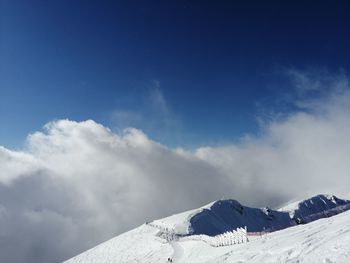 Scenic view of snowcapped mountains against blue sky