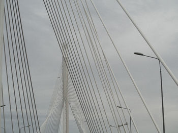 Low angle view of suspension bridge cables against sky