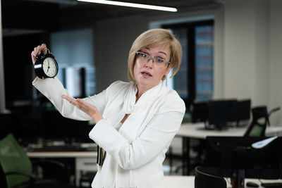 Portrait of young woman standing in office