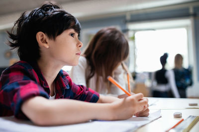 Serious students studying at desk in classroom