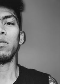 Close-up portrait of man against gray background