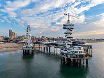 Aerial view of coastal pier with spiral observation tower, ferris wheel, and dome structure framed