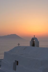 Scenic view of sea and building against orange sky