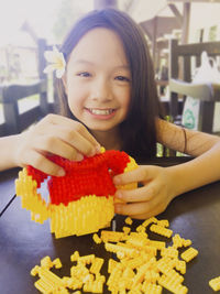 Portrait of smiling young woman with ice cream on table