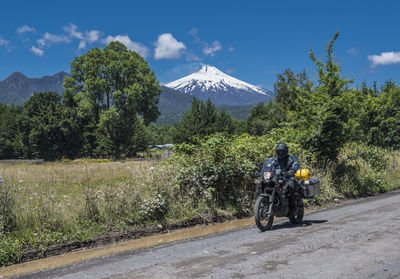 Motorbike rider passing the strato volcano villarica, chile
