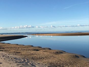 Scenic view of beach against blue sky