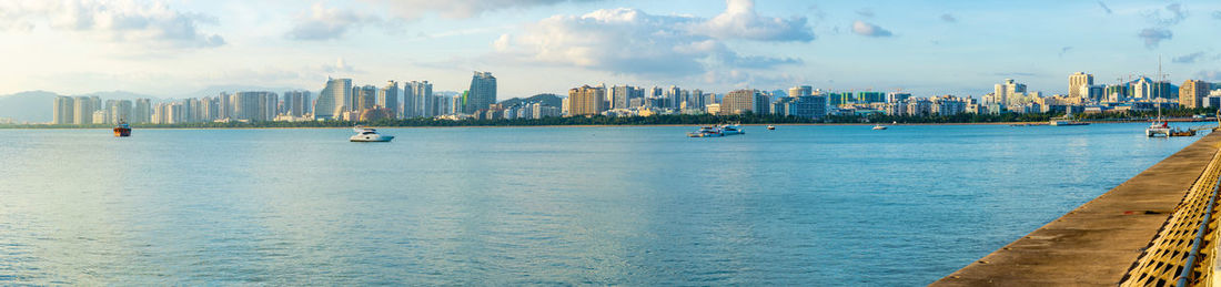 Panoramic view of sea and buildings against sky