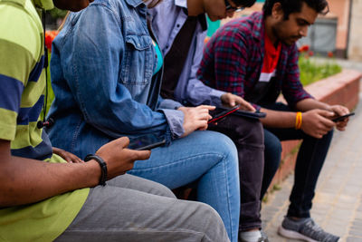 Rear view of people using digital tablet